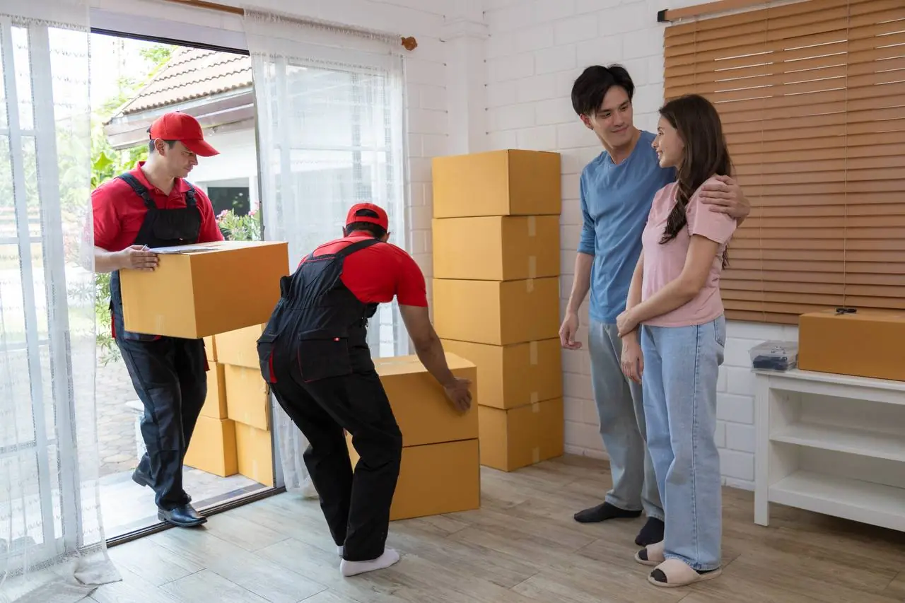 Cross country movers carrying boxes outside home in Wichita, KS