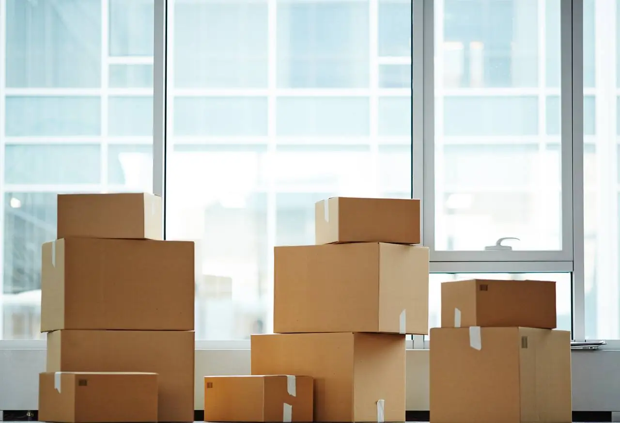 Man carrying stack of cardboard moving boxes in Hartford, CT