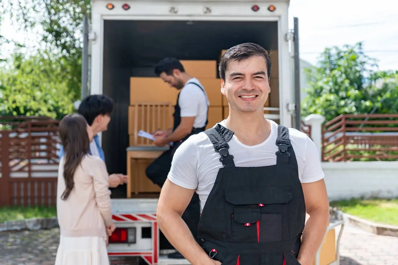 Smiling mover with team loading truck for customers in Pensacola, FL