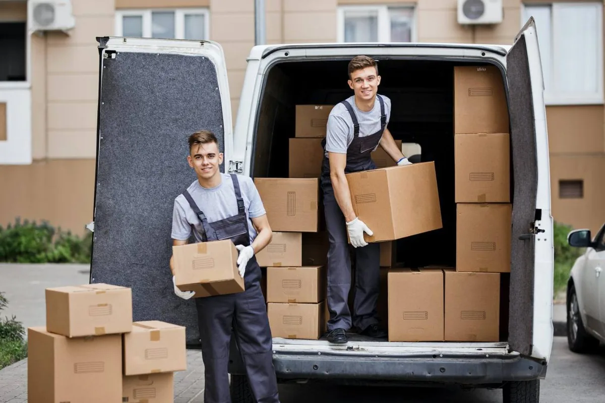 Two professional movers loading boxes into moving van